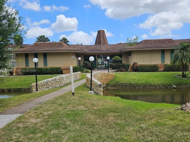 a view of a house with backyard and a fountain