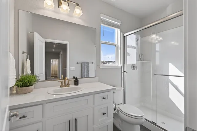 a bathroom with a sink a toilet and shower