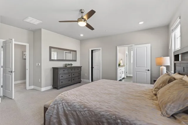 a bedroom with a large bed and a chandelier