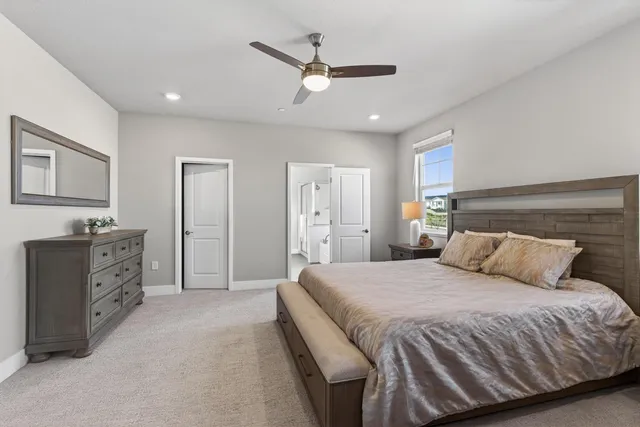 a bedroom with a large bed and ceiling fan