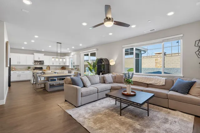 a living room with furniture kitchen view and a chandelier