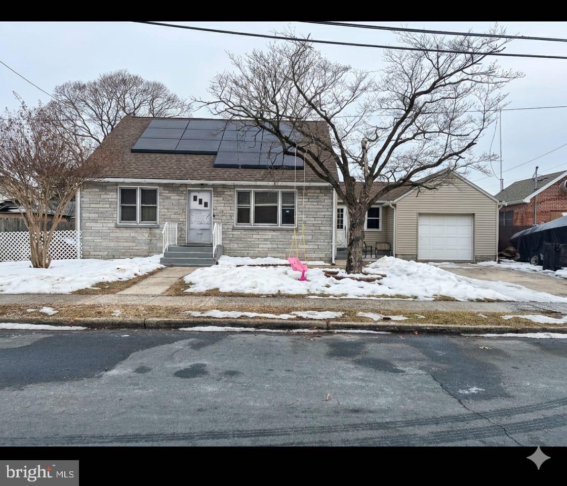 a front view of house with yard covered in snow
