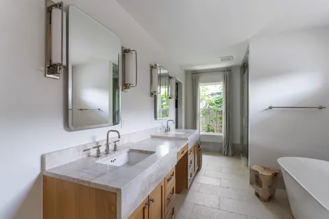 a bathroom with a tub sink and mirror
