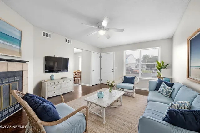 a living room with furniture a flat screen tv and a fireplace