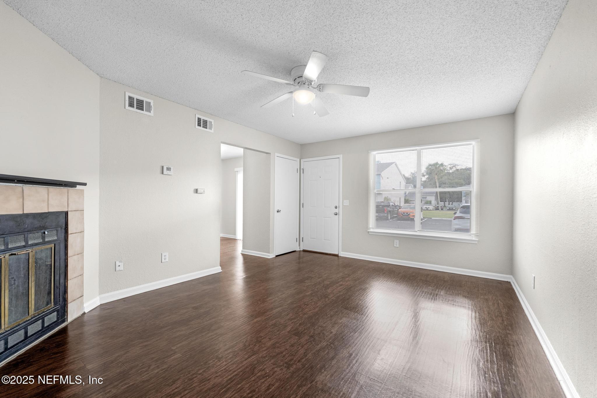791 Assisi Lane, Unit 1503 Jacksonville, FL 32233 - Photo 3 of 25 an empty room with wooden floor chandelier fan and windows