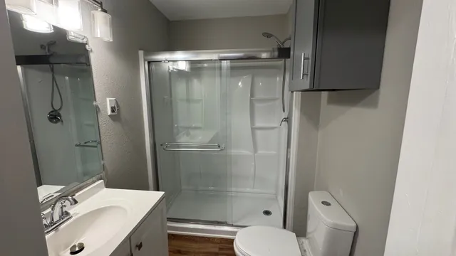 a bathroom with a granite countertop sink toilet and shower