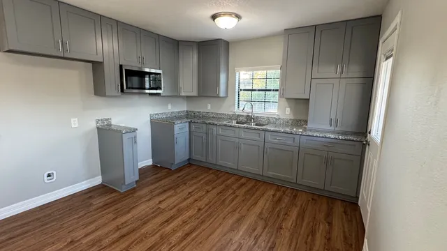 a kitchen with stainless steel appliances granite countertop a sink a stove a microwave and cabinets