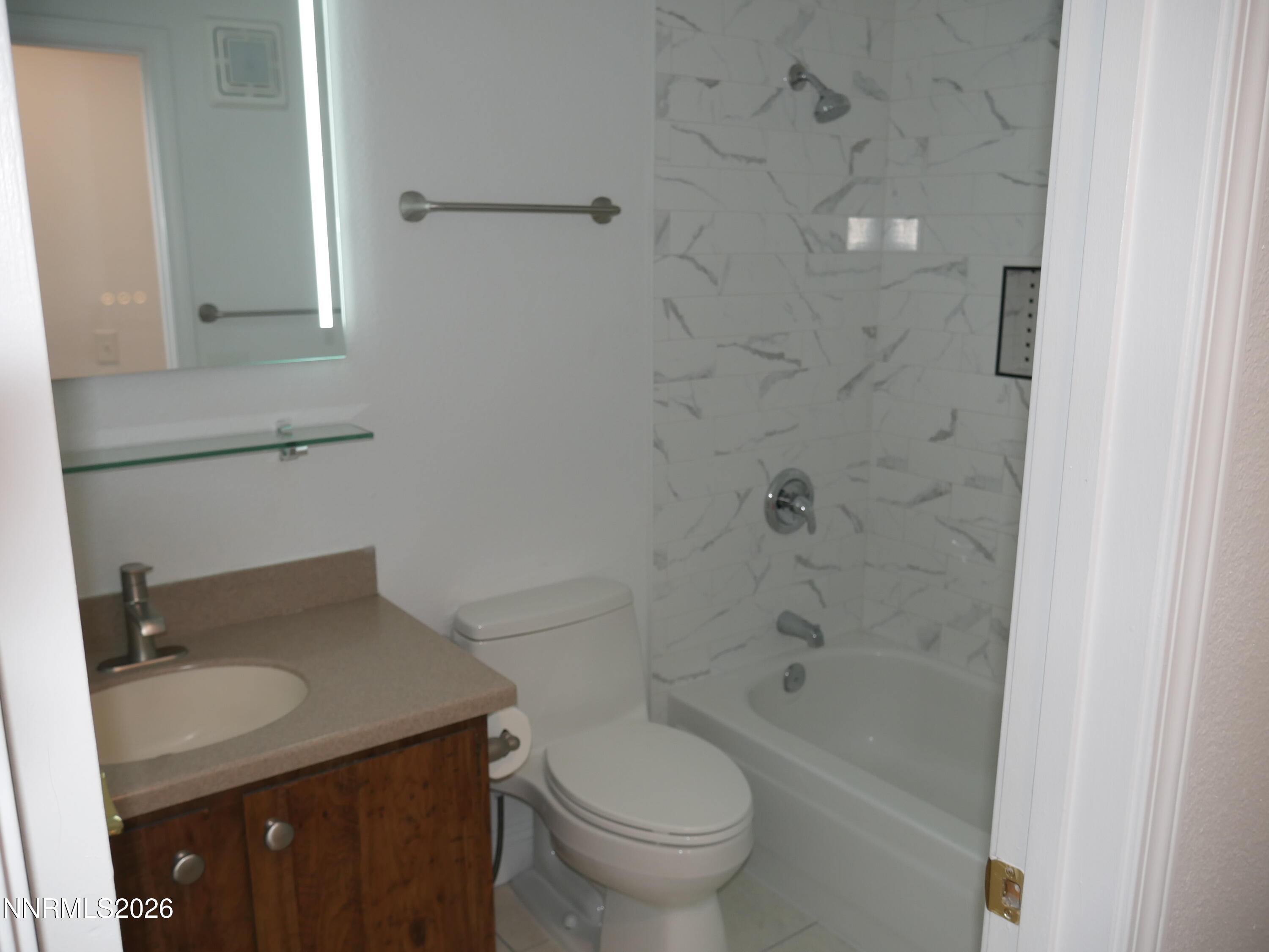 2385 Tripp Drive, Unit 3 Reno, NV 89512 - Photo 29 of 49 a bathroom with a granite countertop toilet a sink and bathtub