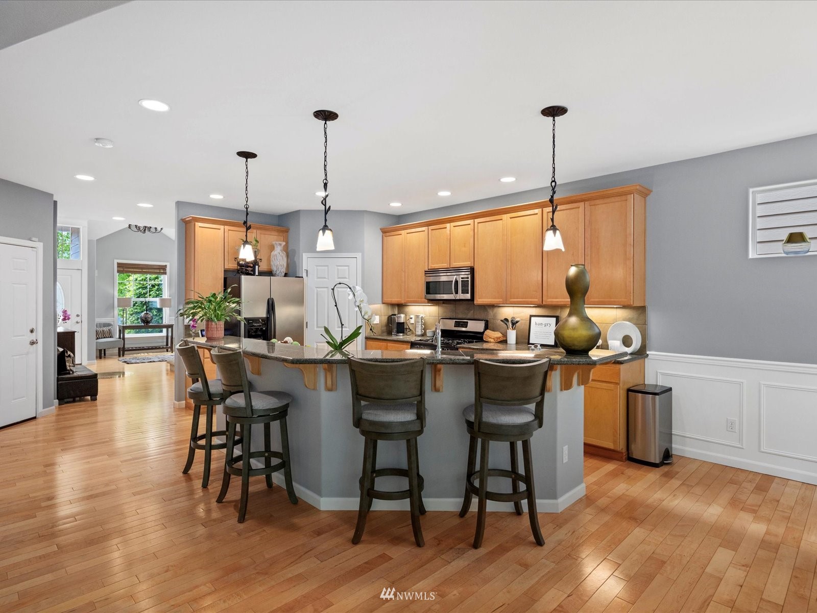 1705 235th Place Southwest Bothell, WA 98021 - Photo 5 of 35 a kitchen with stainless steel appliances a dining table chairs stove and white cabinets