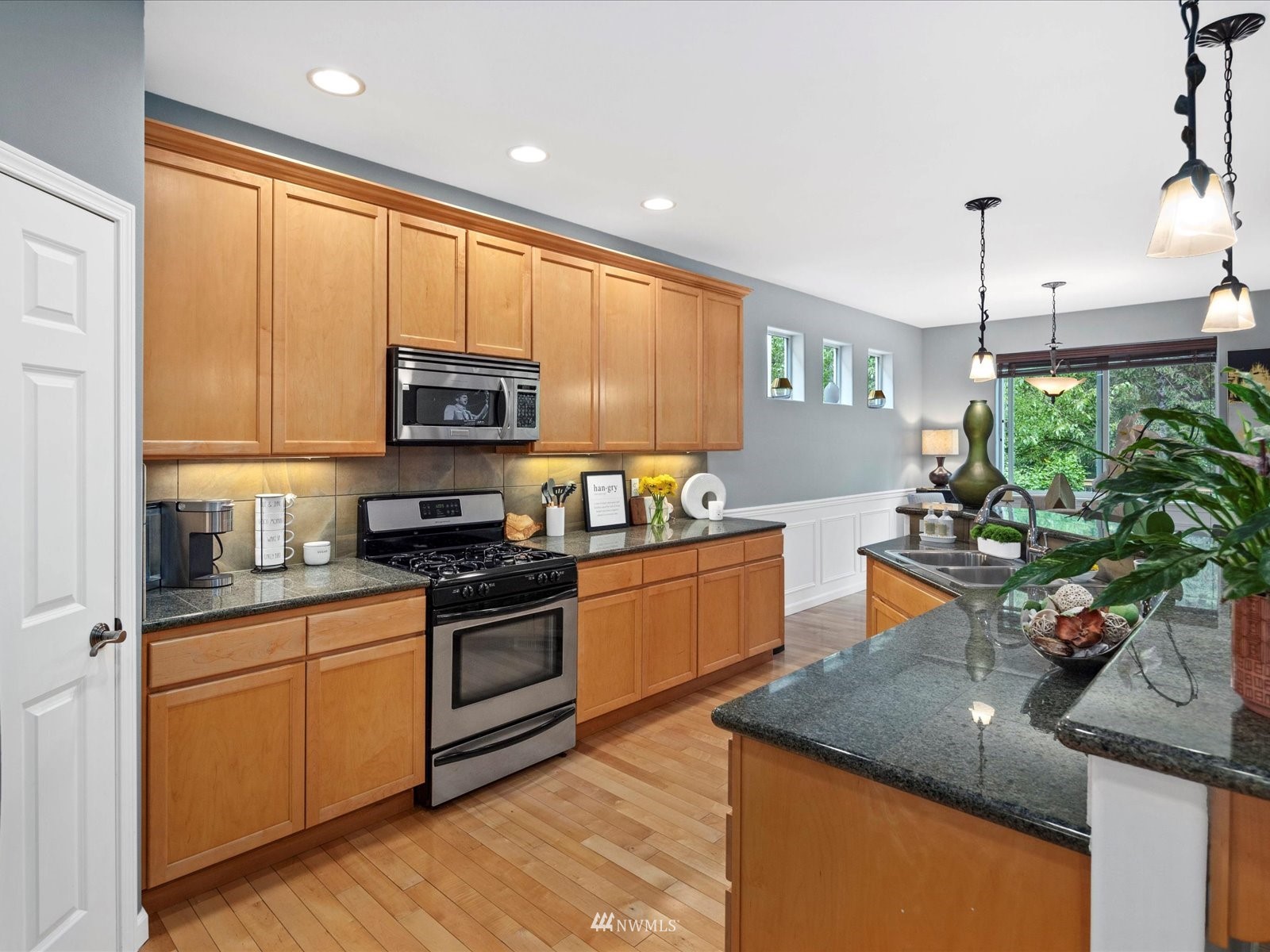 1705 235th Place Southwest Bothell, WA 98021 - Photo 7 of 35 a kitchen with stainless steel appliances granite countertop a sink a stove and a microwave