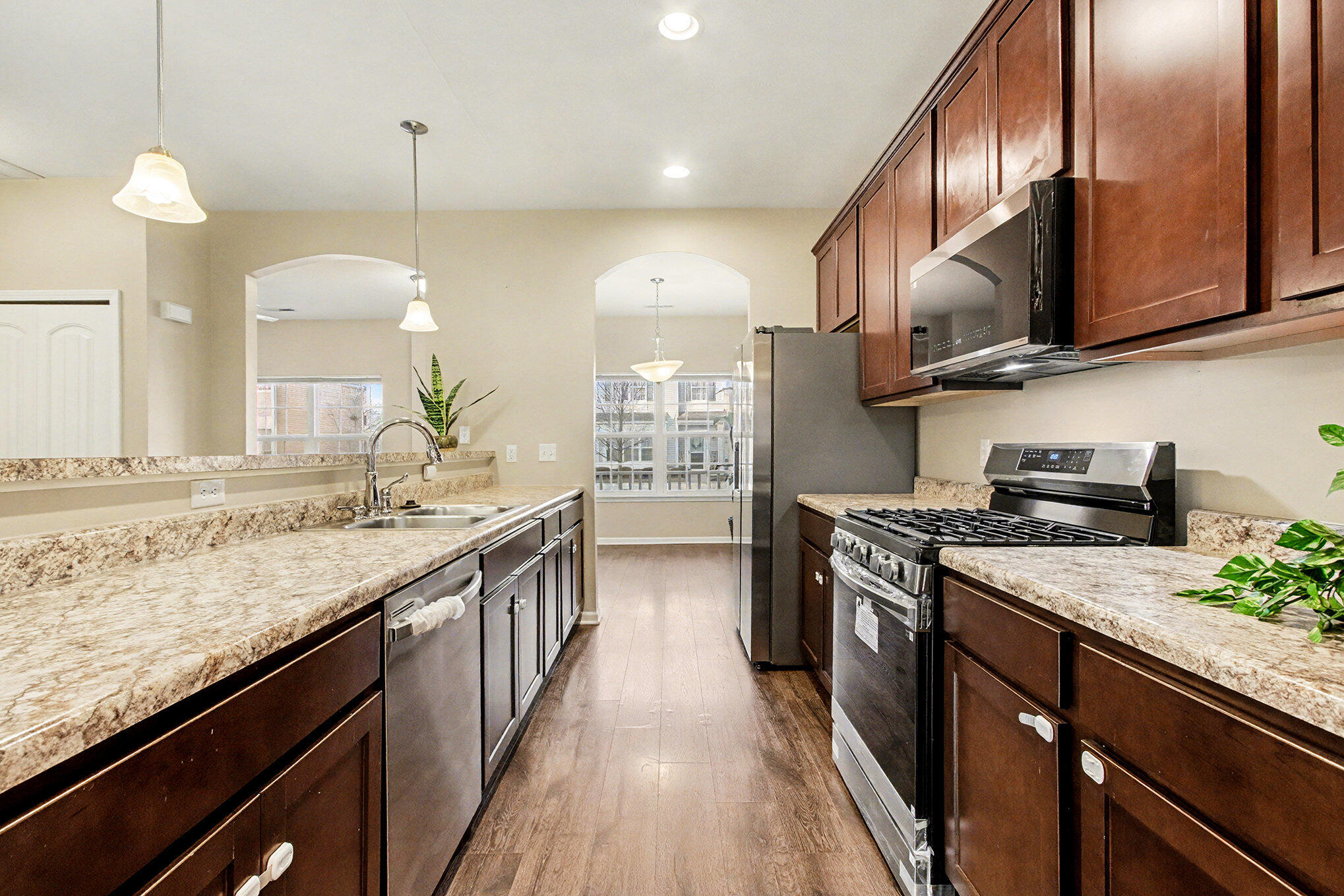 1063 East 116th Place Crown Point, IN 46307 - Photo 11 of 24 a kitchen with stainless steel appliances granite countertop a sink a stove and a wooden floors