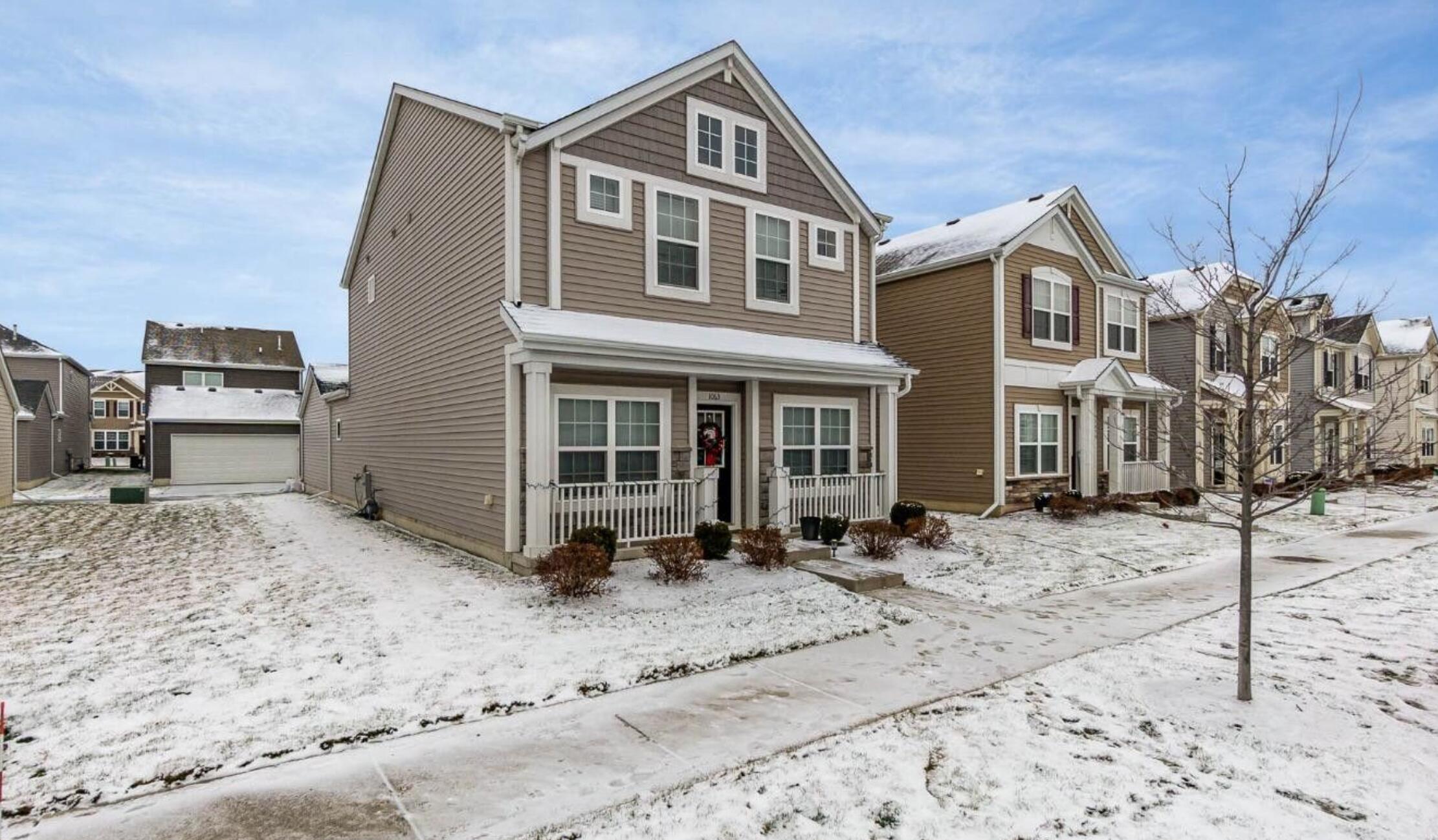 1063 East 116th Place Crown Point, IN 46307 - Photo 2 of 24 a front view of a house with a yard covered with snow in the background