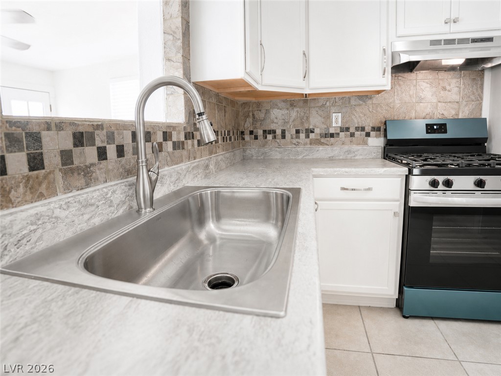 2870 South Sandhill Road Las Vegas, NV 89121 - Photo 28 of 64 Well-lit kitchen with sleek countertops, modern tile backsplash, and essential cooking appliances.