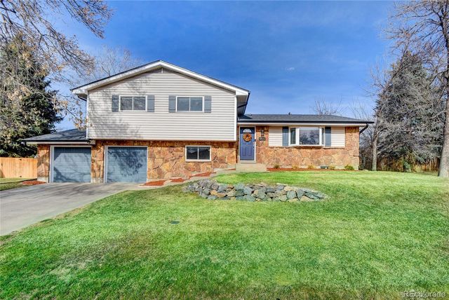 a front view of a house with a yard and trees