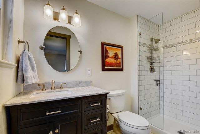 a bathroom with a toilet a sink a light fixture and mirror