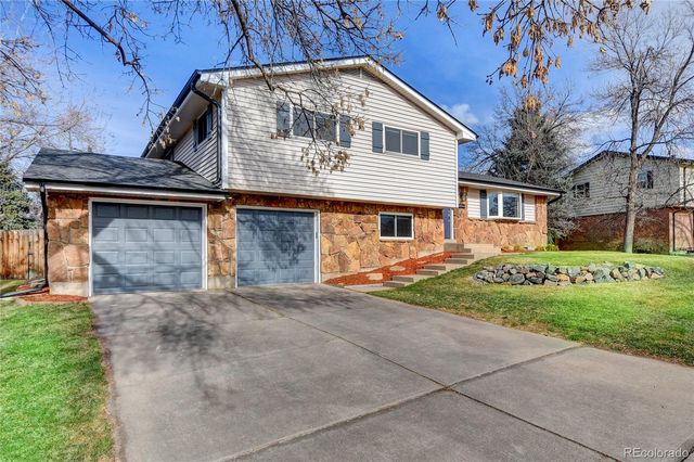 a front view of a house with a garden and garage