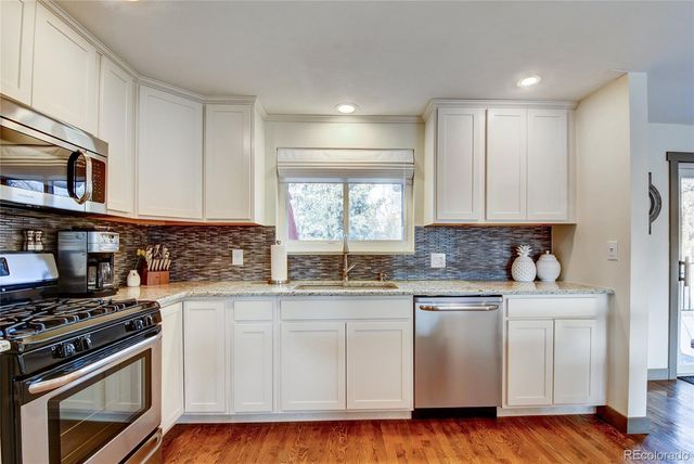 a kitchen with stainless steel appliances granite countertop a stove and a sink