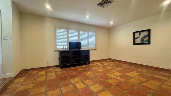 a bedroom with a large bed and wooden floor