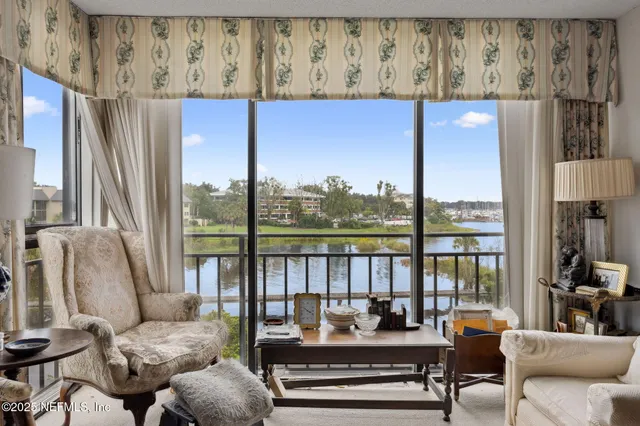 a living room with furniture and a floor to ceiling window