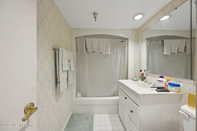 a bathroom with a sink mirror vanity and bathtub