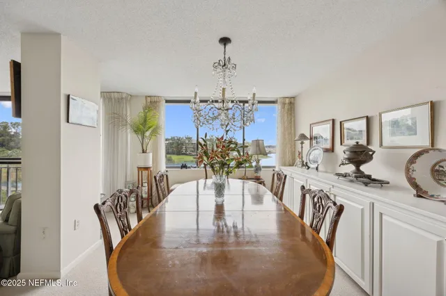 a view of a dining room with furniture a chandelier and wooden floor