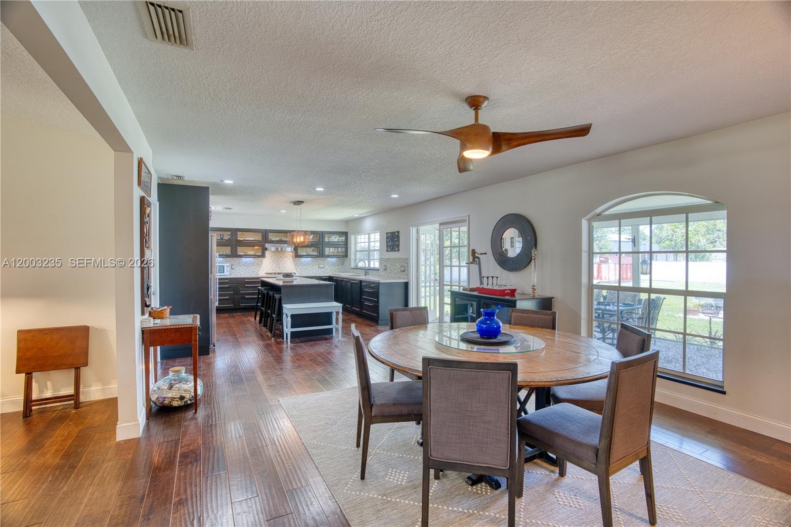 16078 Mellen Lane Jupiter, FL 33478 - Photo 11 of 57 a dining room with furniture a window and wooden floor