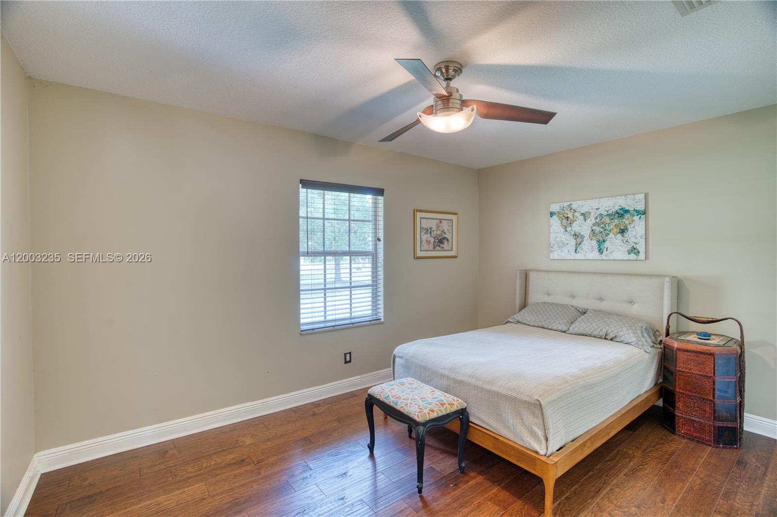 16078 Mellen Lane Jupiter, FL 33478 - Photo 31 of 57 a bedroom with a bed a chandelier and a window