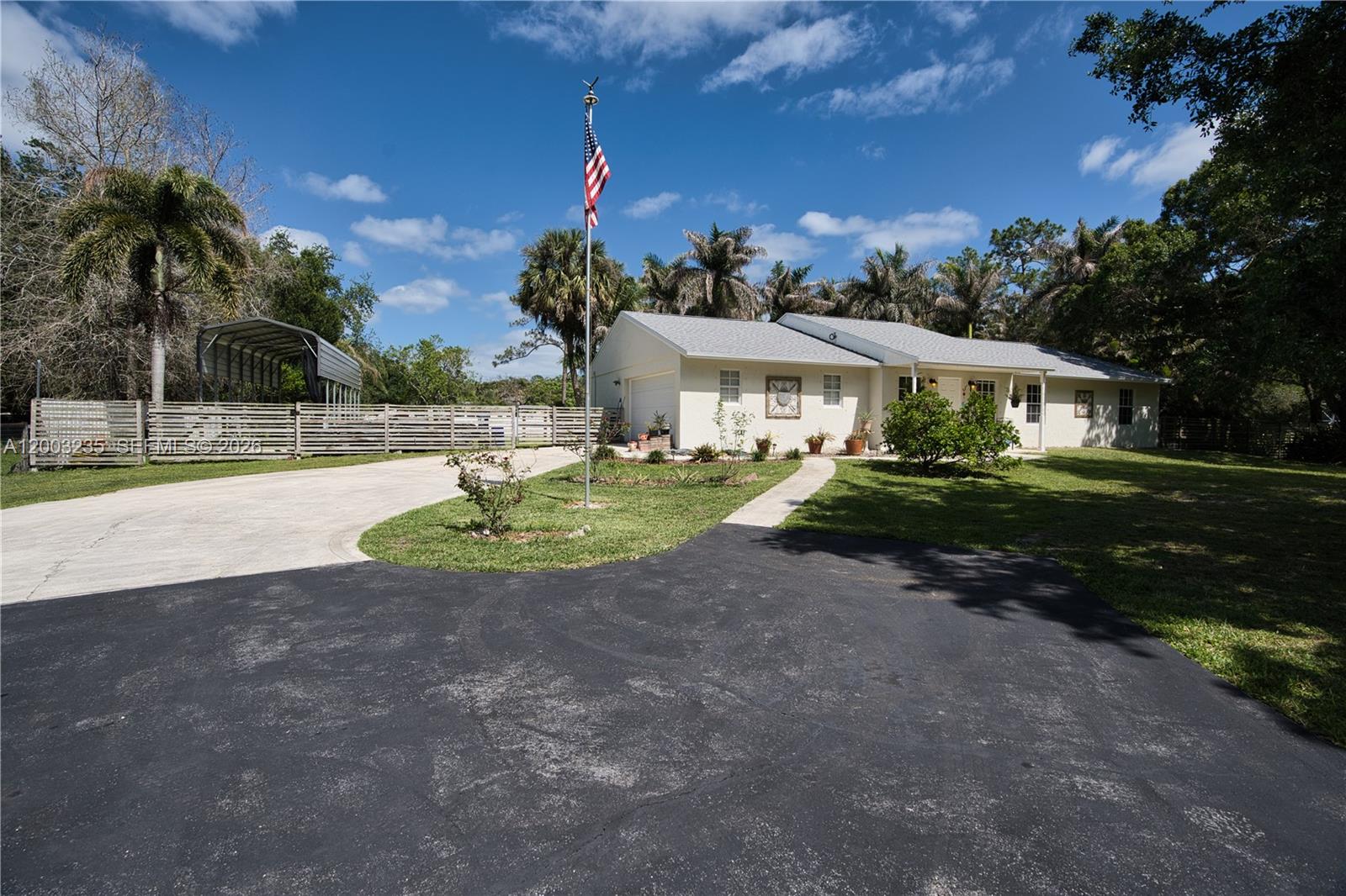 16078 Mellen Lane Jupiter, FL 33478 - Photo 46 of 57 a view of a white house with a yard plants and palm trees