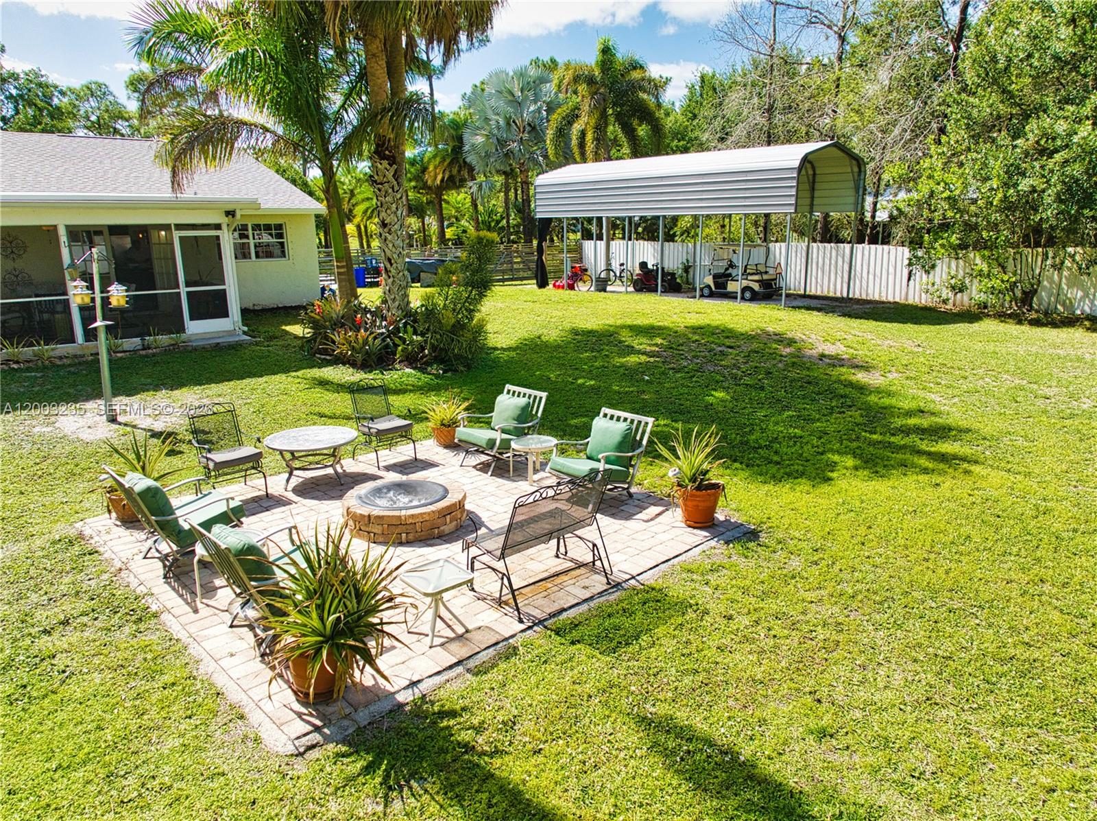 16078 Mellen Lane Jupiter, FL 33478 - Photo 57 of 57 a view of a patio with table and chairs potted plants and large tree