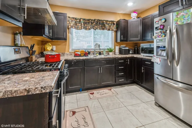 a kitchen with stainless steel appliances granite countertop a refrigerator and a stove