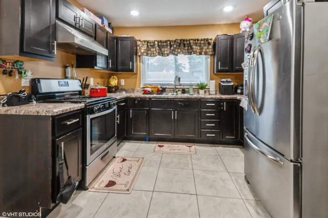 a kitchen with stainless steel appliances granite countertop a refrigerator and a stove