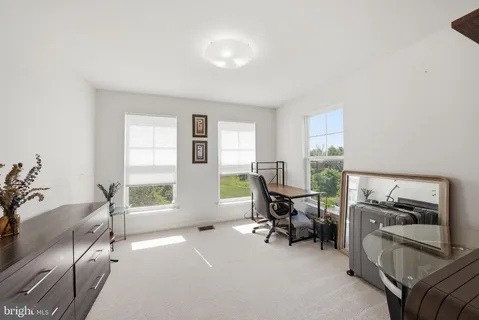 a view of a livingroom with workspace and a window