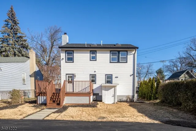 a view of a white house with a sink and yard in front of it