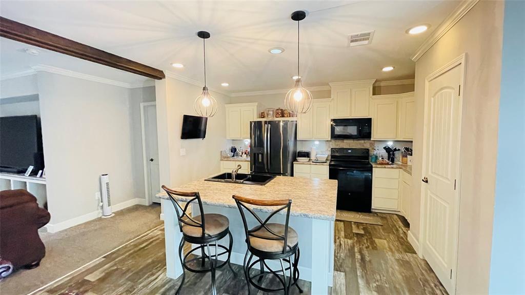 8394 Lake Road Mansfield, TX 76063 - Photo 10 of 22 a kitchen with stainless steel appliances kitchen island granite countertop a refrigerator a stove a microwave oven a sink with a dining table and chairs with wooden floor