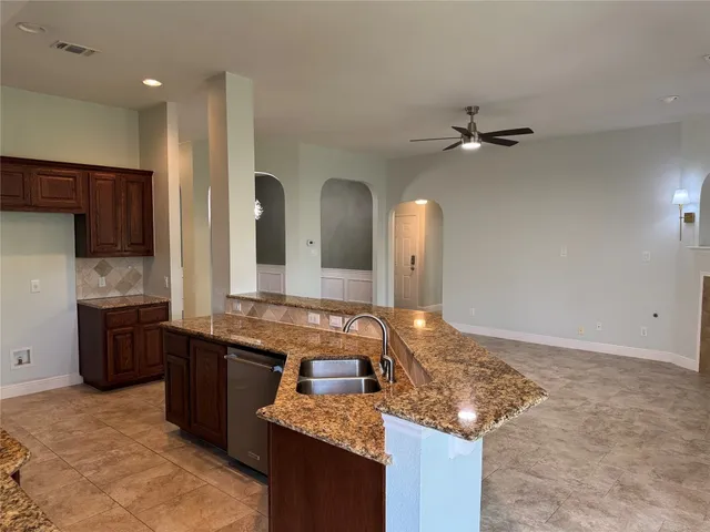 a large kitchen with kitchen island granite countertop a sink and a stove