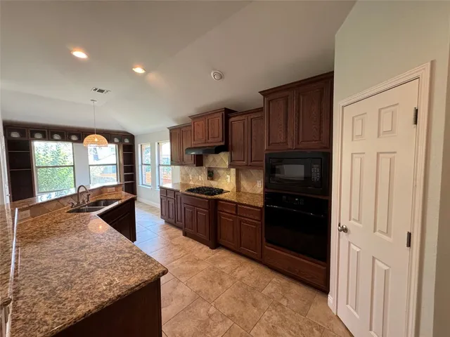 a kitchen with stainless steel appliances granite countertop a stove sink and cabinets