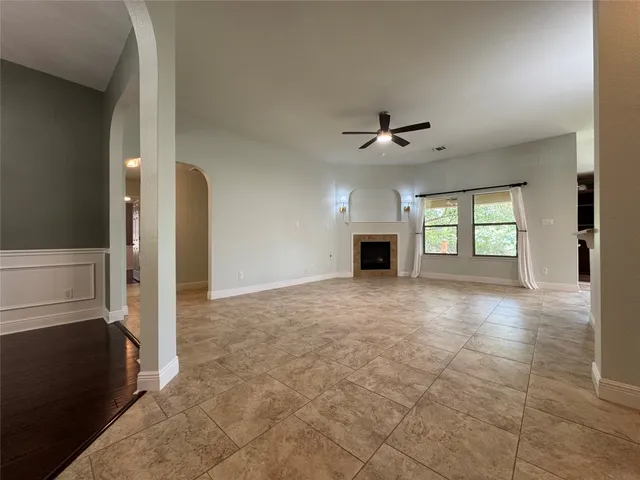 an empty room with windows and ceiling fan