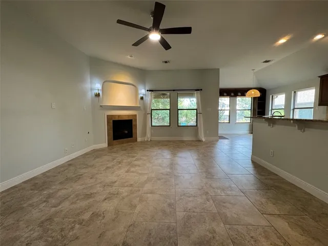 an empty room with windows and fireplace