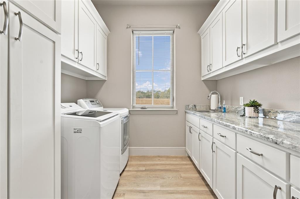 1180 Wiggins Road Maypearl, TX 76064 - Photo 24 of 40 Built-in cabinetry and a stone countertop with integrated sink make laundry day a breeze.
