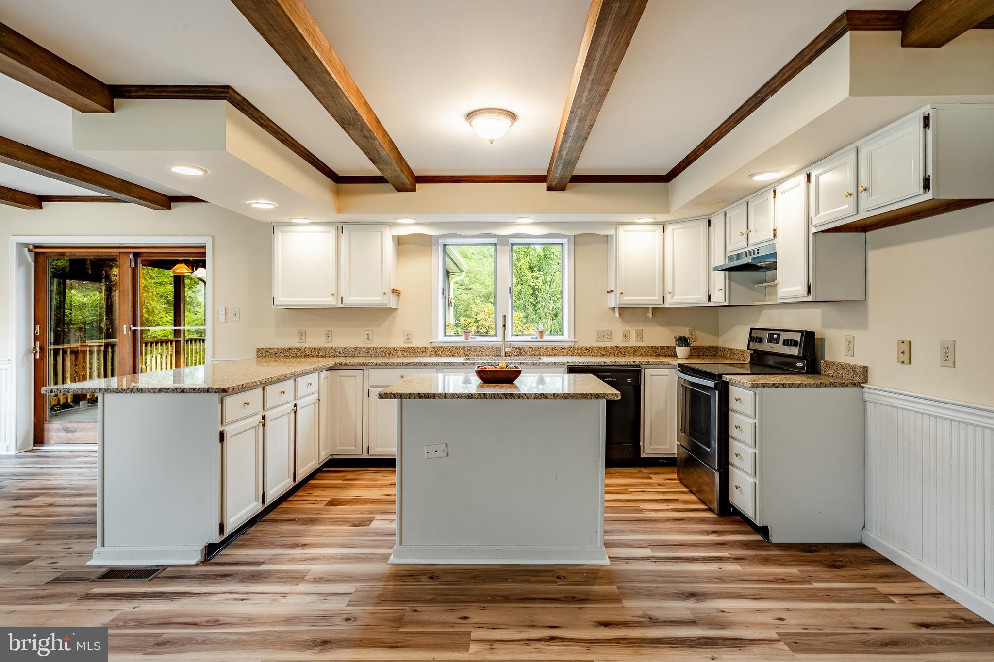 249 Mattson Road Garnet Valley, PA 19060 - Photo 15 of 53 a kitchen with stainless steel appliances kitchen island granite countertop wooden floors and white cabinets