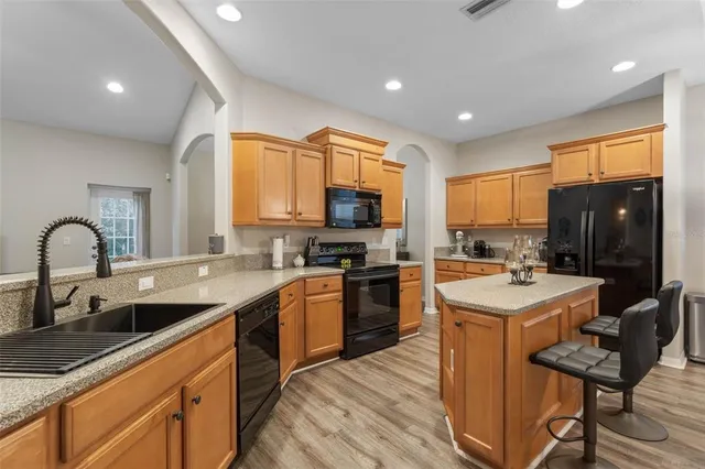 a kitchen with stainless steel appliances granite countertop a sink stove and refrigerator