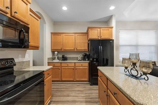 a kitchen with stainless steel appliances granite countertop a sink a stove and a microwave