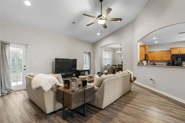a living room with furniture kitchen view and a chandelier