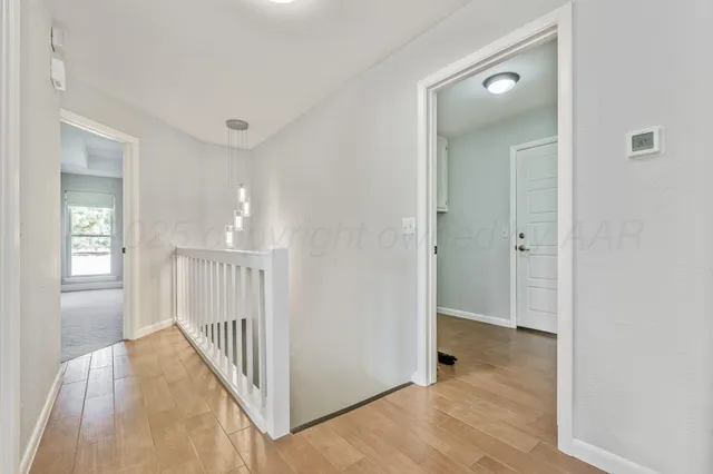 a view of a hallway with wooden floor and stairs