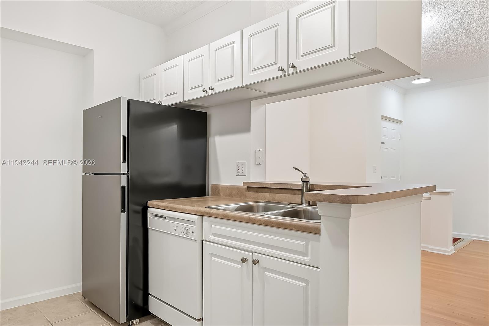 a kitchen with stainless steel appliances granite countertop white cabinets and refrigerator