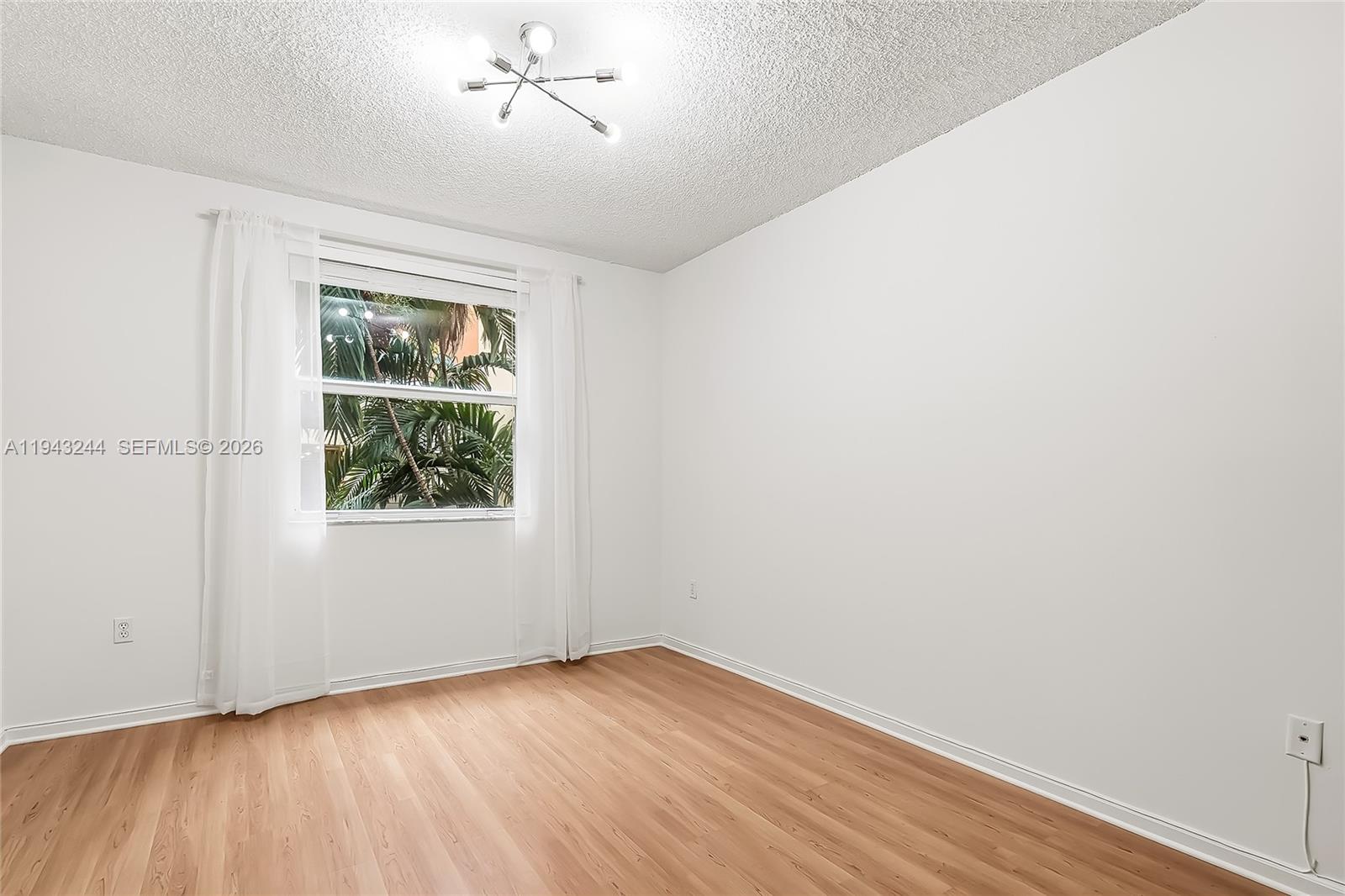 17150 North Bay Road, Unit 2301 Sunny Isles Beach, FL 33160 - Photo 12 of 44 an empty room with wooden floor and windows