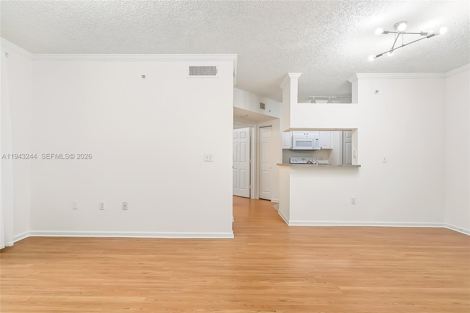 17150 North Bay Road, Unit 2301 Sunny Isles Beach, FL 33160 - Photo 7 of 44 a view of kitchen and empty room with wooden floor