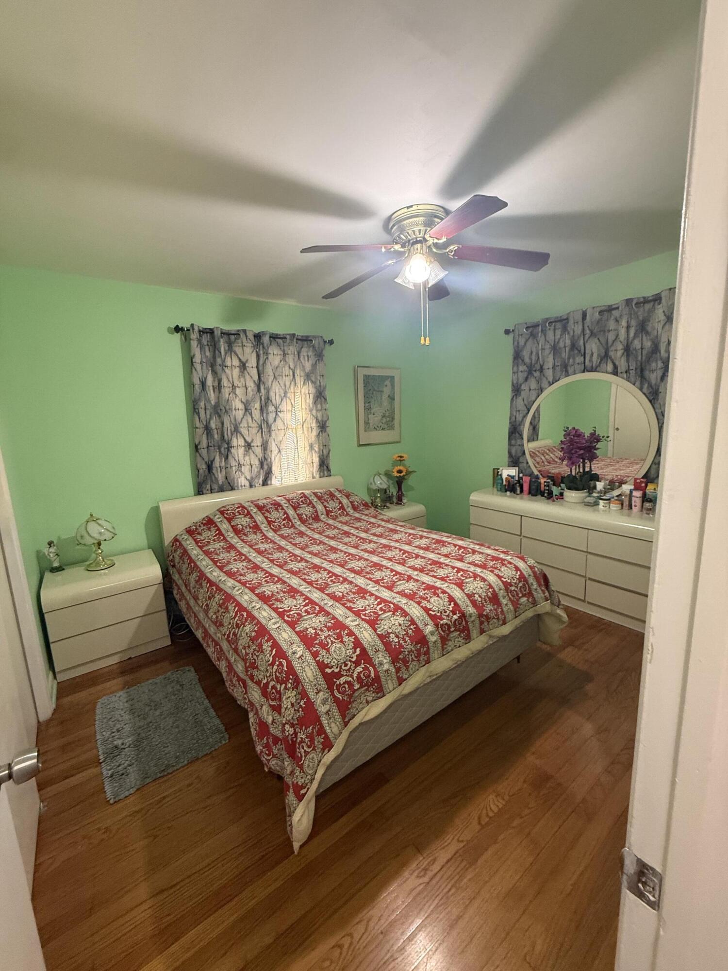 1203 Mathis Street Lake Worth, FL 33461 - Photo 9 of 19 a bedroom with a bed mirror and a window