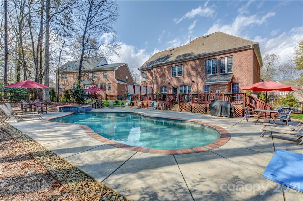 a view of swimming pool with a table and chairs under an umbrella