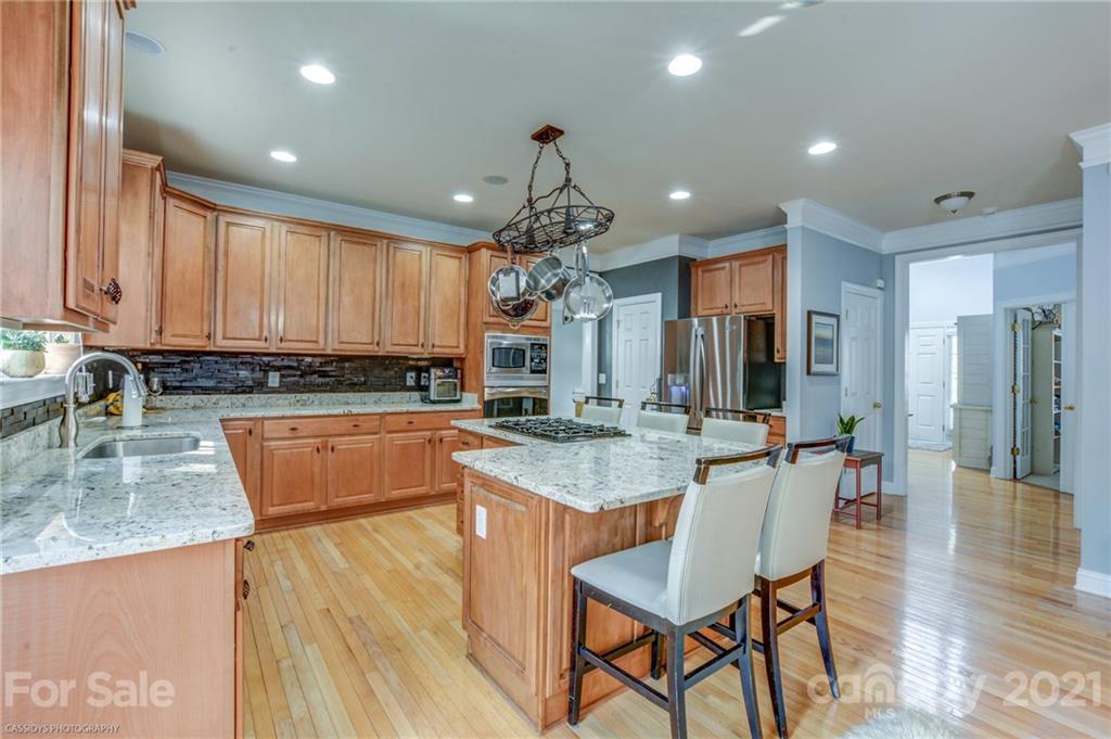 2678 Landing Pointe Drive Clover, SC 29710 - Photo 5 of 48 a kitchen with stainless steel appliances granite countertop wooden cabinets a stove top oven a sink and dishwasher